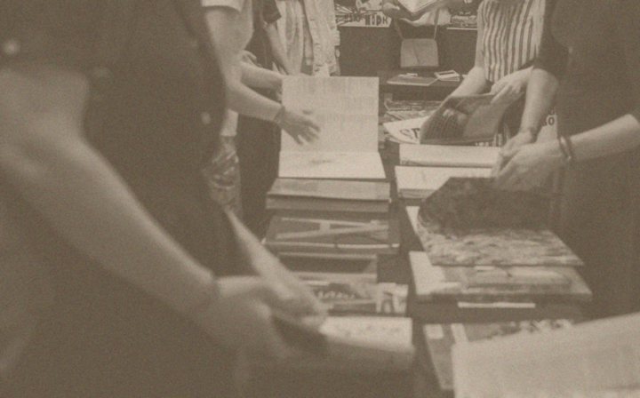 Hands browsing a table of books